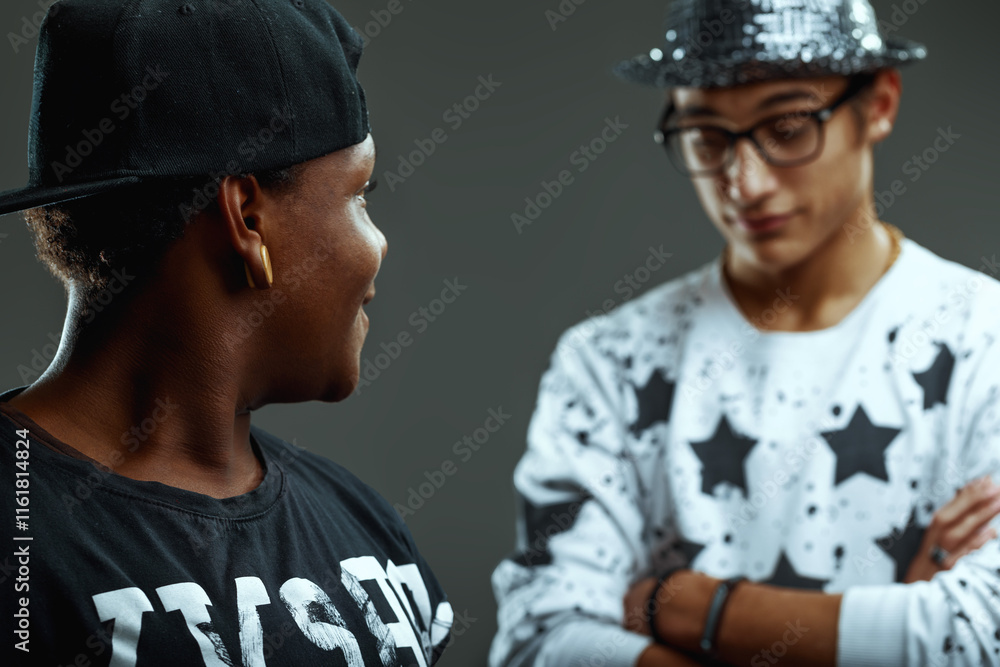 Obraz premium Two young rappers talking and exchanging opinions on grey backgr