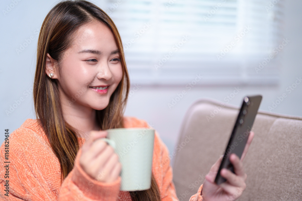 A woman multitasking, holding a mug of coffee in one hand and checking her smartphone with the other, seated comfortably on a sofa A woman multitasking, holding a mug of coffee in one hand and checking her smartphone with the other, seated comfortably on a sofa