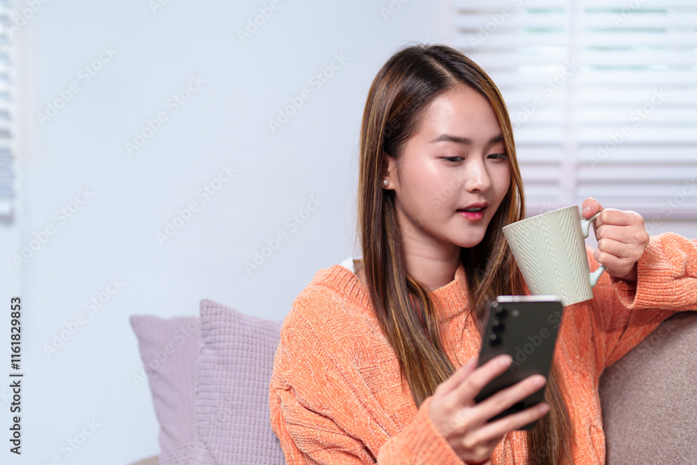 A woman multitasking, holding a mug of coffee in one hand and checking her smartphone with the other, seated comfortably on a sofa A woman multitasking, holding a mug of coffee in one hand and checking her smartphone with the other, seated comfortably on a sofa