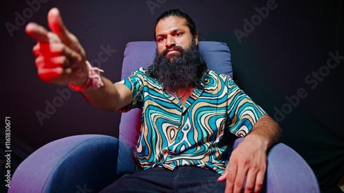 Sitting bearded man making a threatening gesture