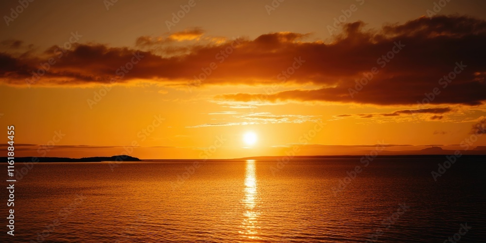 Fototapeta premium Fiery sunset over calm ocean waters.