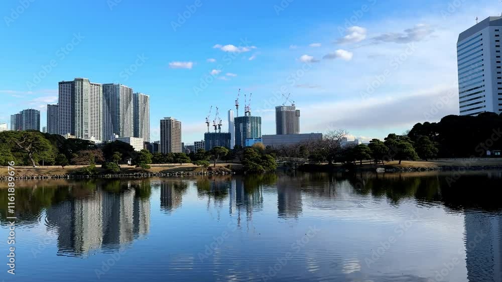 A serene reflection of skyscrapers and nature in Hama Rikyu Gardens, Tokyo A serene reflection of skyscrapers and nature in Hama Rikyu Gardens, Tokyo