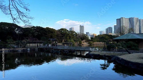 Wallpaper Mural A serene Japanese garden with a tranquil pond, wooden bridge, and modern skyline Torontodigital.ca