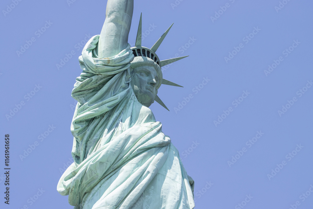 Fototapeta premium Closeup of the Statue of Liberty on the Liberty Island in New York against a clear blue sky.