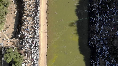 Aerial footage over Ethiopian Timkat baptism Ceremony in water Resrvoir
Drone view over Ethiopian Timkat Ceremony Gathering at reservoir for baptism
, Axum, Ethiopia,19.1.2020
 photo