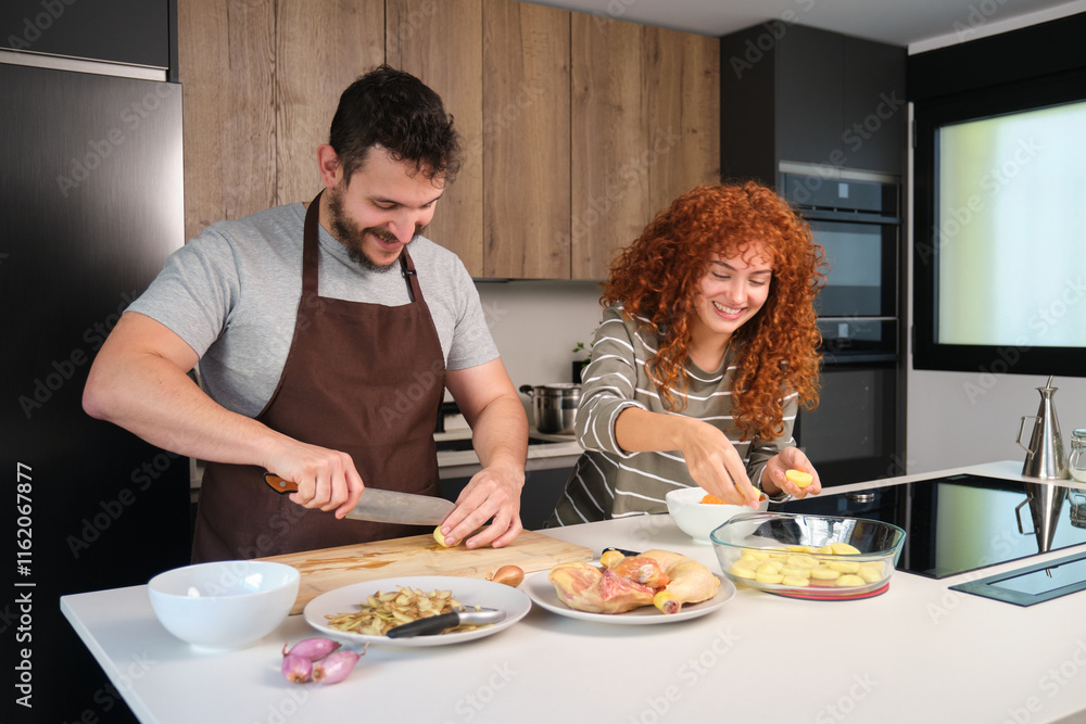 Couple preparing chicken with potatoes and onions in modern kitchen Couple preparing chicken with potatoes and onions in modern kitchen