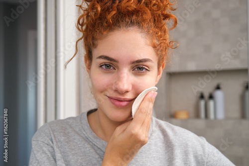 Woman uses reusable makeup remover pad, embrace sustainable beauty