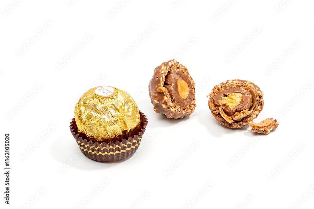 One whole Ferrero Rocher chocolate candy and one cut in half lie on a ...