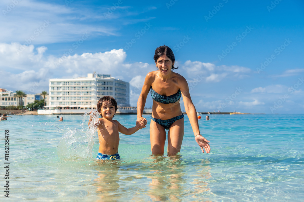 Fototapeta premium A woman and a child are playing in the ocean