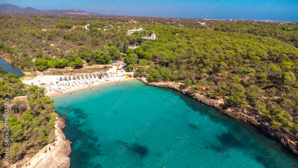 Obraz premium Tourists enjoying the turquoise waters of cala s'amarador beach in mallorca, spain