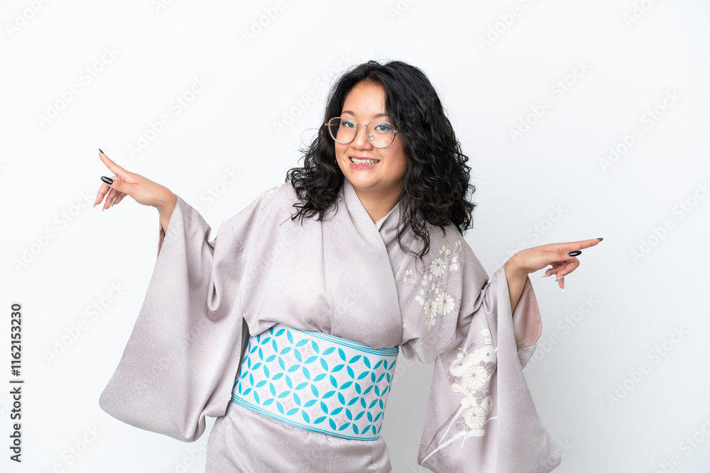 Young asian woman wearing kimono isolated on white background pointing finger to the laterals and happy