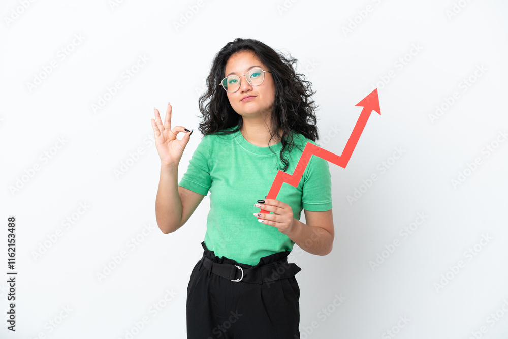 Young asian woman isolated on white background holding a catching a rising arrow and doing OK sign Young asian woman isolated on white background holding a catching a rising arrow and doing OK sign