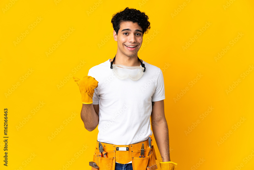 Venezuelan electrician man isolated on yellow background pointing to the side to present a product Venezuelan electrician man isolated on yellow background pointing to the side to present a product