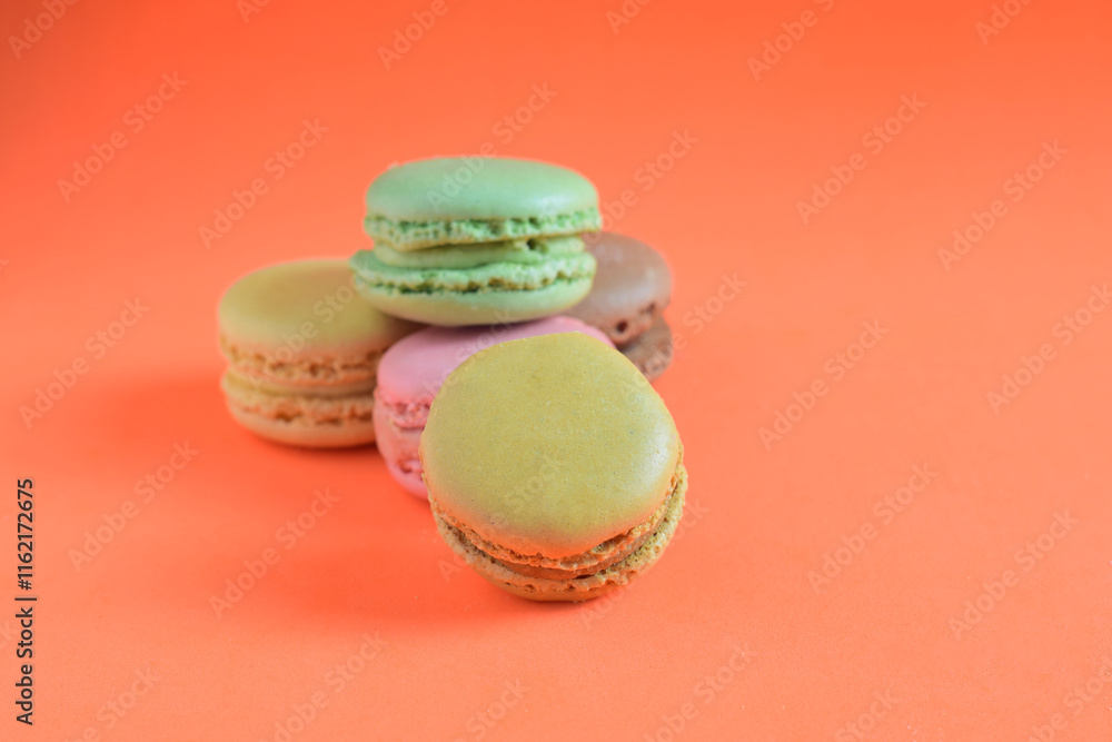 Macarons stacked, isolated, on orange background and copy space. Macarons stacked, isolated, on orange background and copy space.