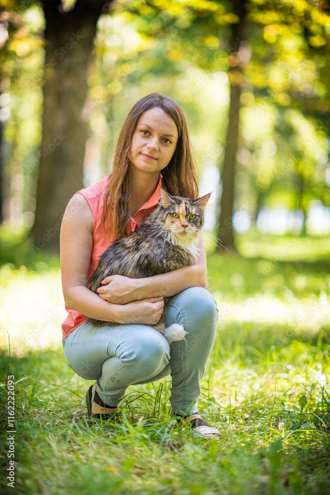 Portrait of a young beautiful long-haired girl, in light clothes in the summer, in the park with a cat. Portrait of a young beautiful long-haired girl, in light clothes in the summer, in the park with a cat.