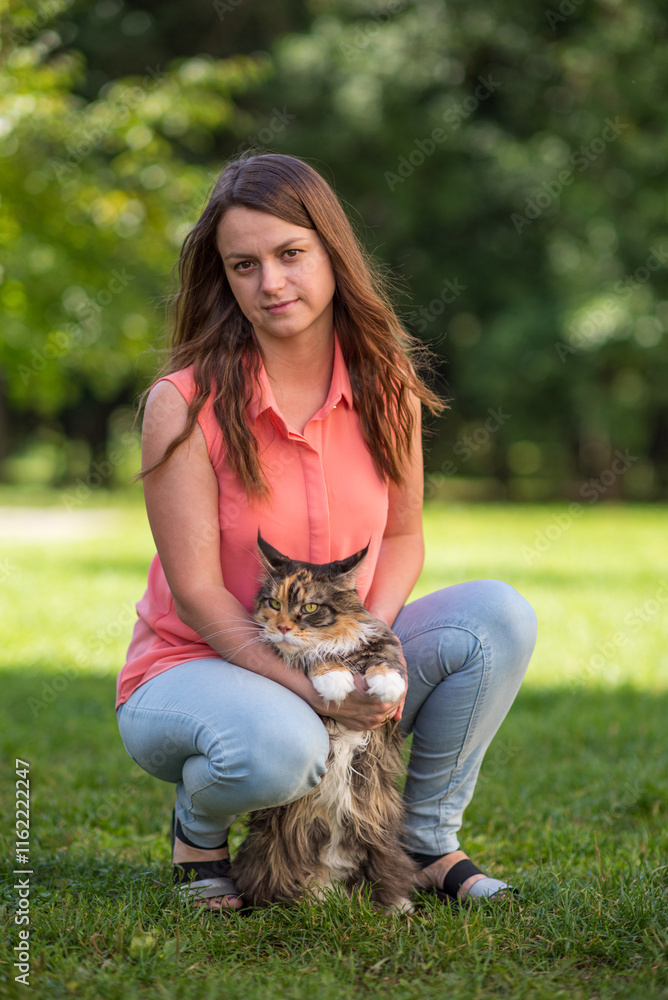Portrait of a young beautiful long-haired girl, in light clothes in the summer, in the park with a cat. Portrait of a young beautiful long-haired girl, in light clothes in the summer, in the park with a cat.
