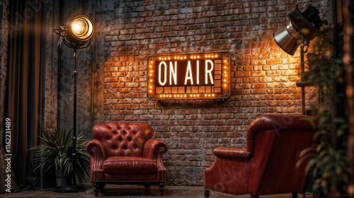 A room with a brick wall and two red leather armchairs. A neon sign reading “On Air” hangs on the wall. For live broadcasts.