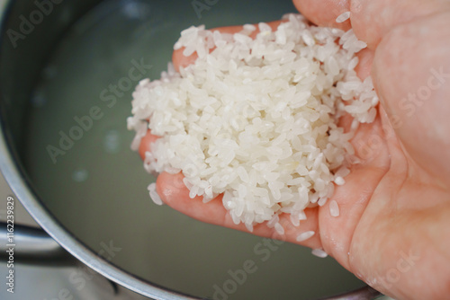 Rice is washed in a saucepan before cooking. grain processing before cooking rice dishes. photo