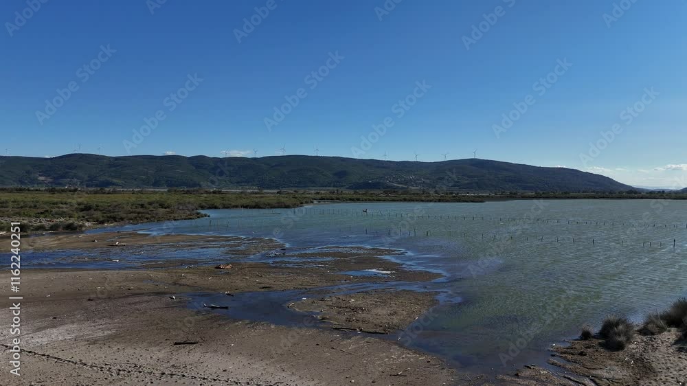 A breathtaking aerial view of the Marmara Sea meeting Lake Nilüfer, showcasing a rich ecosystem teeming with birds under a clear blue sky A breathtaking aerial view of the Marmara Sea meeting Lake Nilüfer, showcasing a rich ecosystem teeming with birds under a clear blue sky
