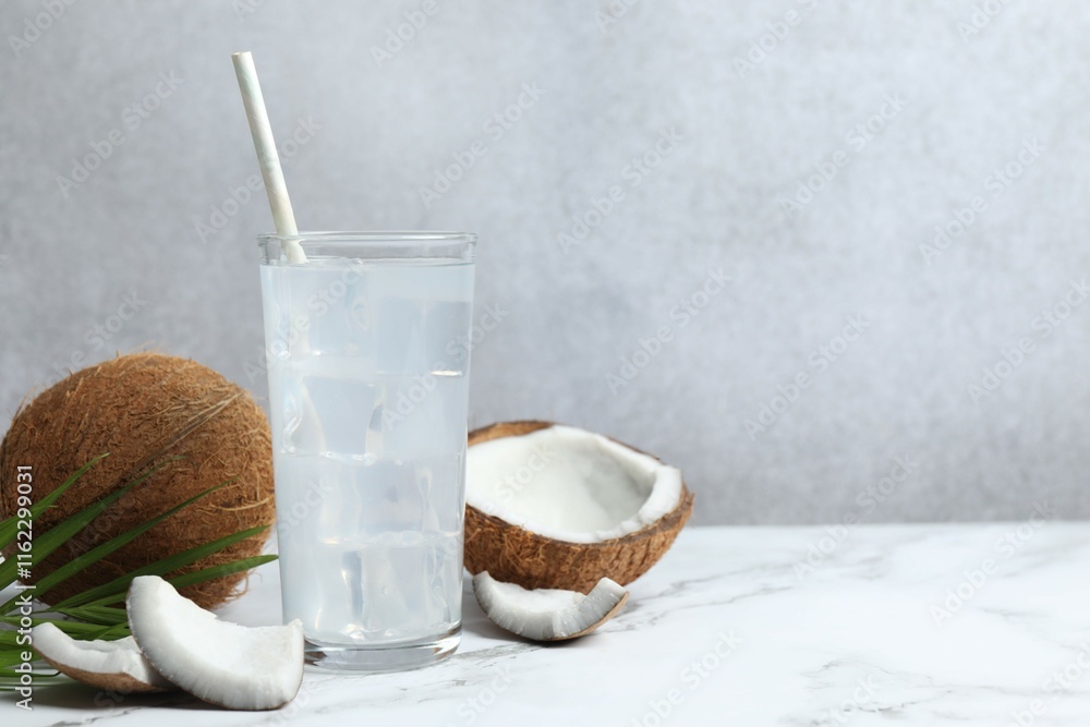 Glass with coconut water with nuts on wooden table