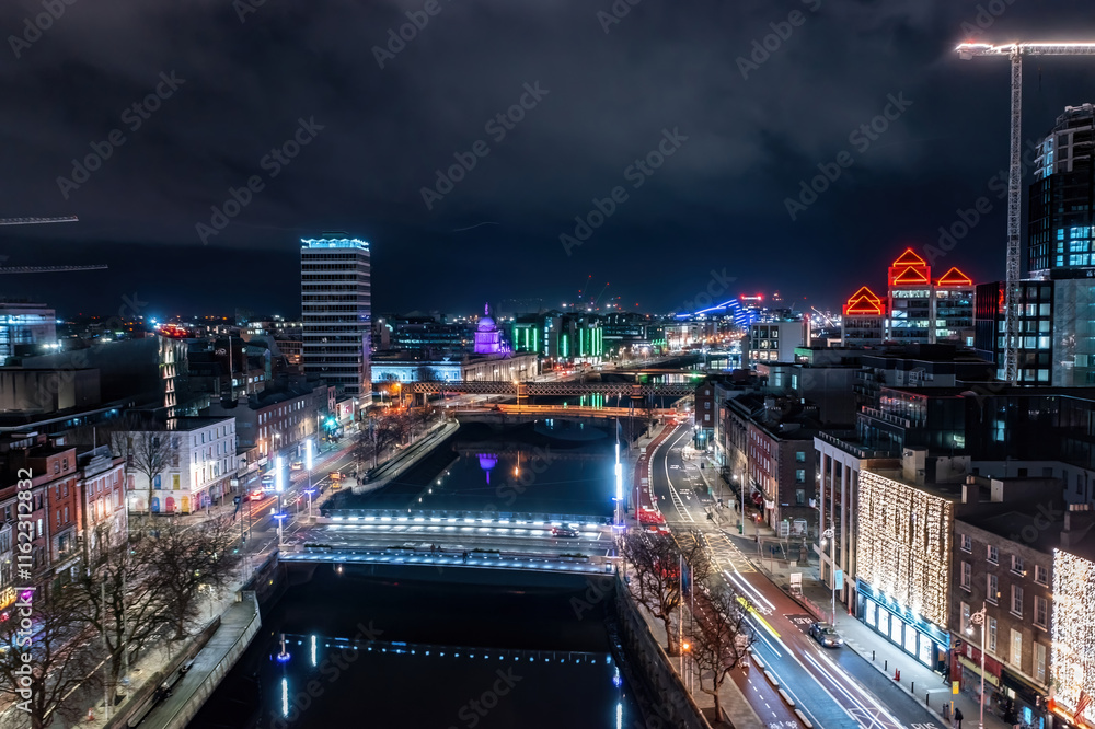 Fototapeta premium Long exposure aerial shot of Dublin at night, highlighting the city's stunning architecture and festive winter lights. Aerial