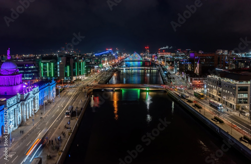 Stunning aerial view of Dublin city center during Christmas, featuring Samuel Beckett Bridge and car light trails
