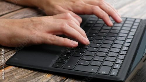 Woman's hands typing on a laptop keyboard