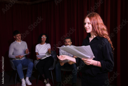 Foto Professional actors reading their scripts during rehearsal in theatre