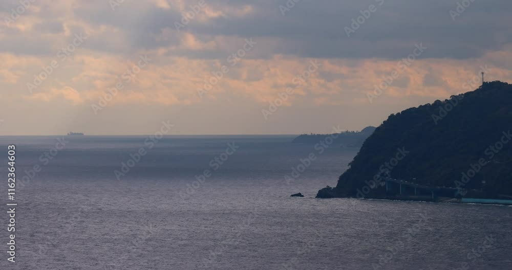岬と水平線が見える海の夕景。 岬と水平線が見える海の夕景。