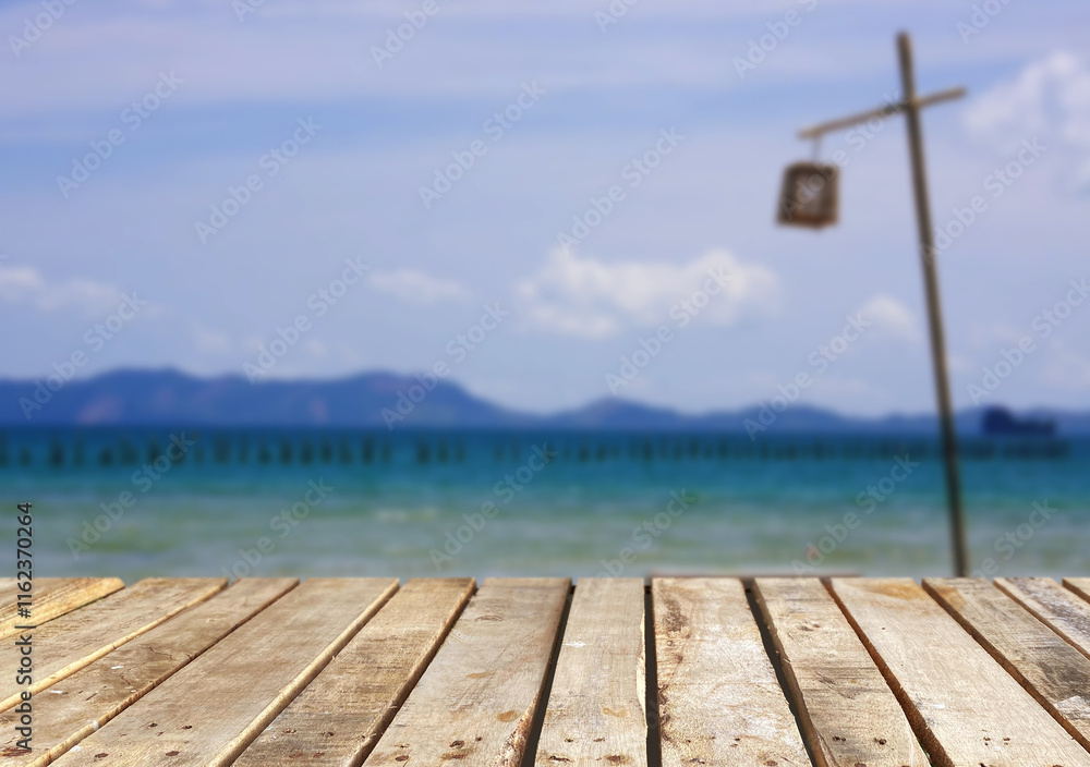 Fototapeta premium Wooden table top on the beach or sea.Party on the beach sunshine time concept.For montage product display or design key visual layout.View of copy space.