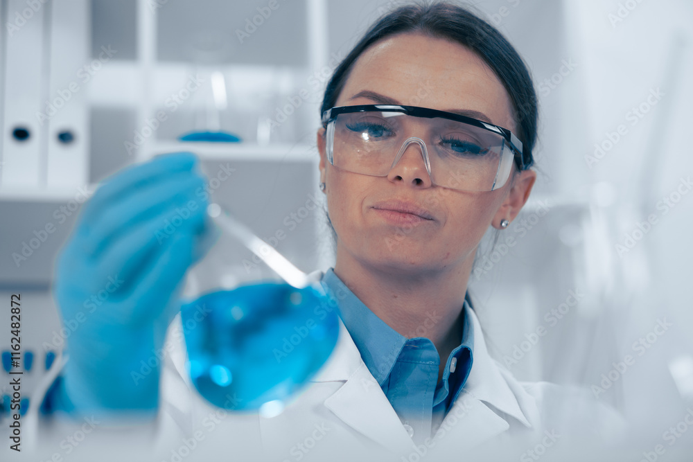 A female scientist is conducting an indepth analysis of a blue solution in her laboratory, showcasing her expertise in biochemistry and biotechnology through meticulous research and testing A female scientist is conducting an indepth analysis of a blue solution in her laboratory, showcasing her expertise in biochemistry and biotechnology through meticulous research and testing