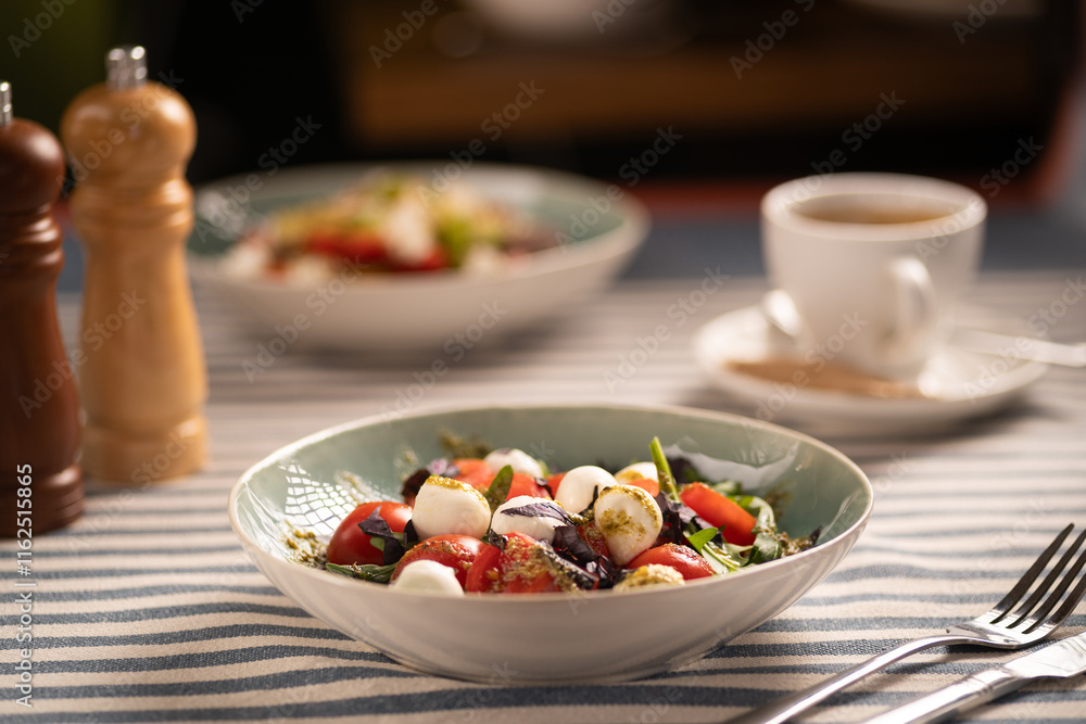 Classic Caprese salad with fresh tomatoes, mozzarella, and basil served on plate in restaurant. elegant dish, vibrant and flavorful, garnished with olive oil and balsamic. Classic Caprese salad with fresh tomatoes, mozzarella, and basil served on plate in restaurant. elegant dish, vibrant and flavorful, garnished with olive oil and balsamic.
