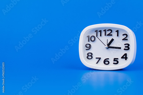 Wallpaper Mural Clock tells the time of work and life appointments. Working on time. White alarm clock on a blue screen. Torontodigital.ca