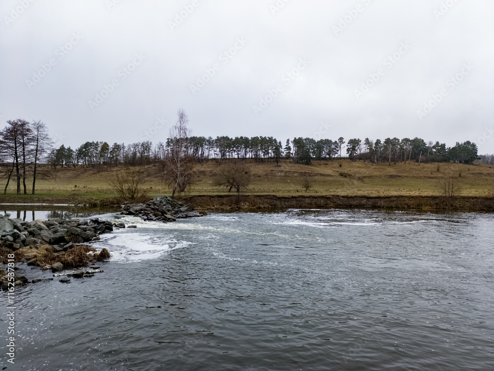 A body of water with rocks and trees in the background A body of water with rocks and trees in the background