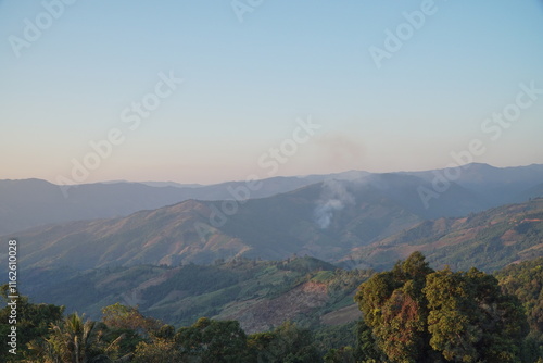 Landscape of Morning Mist with Mountain Layer at north of Thailand. mountain ridge and clouds in rural jungle bush forest.