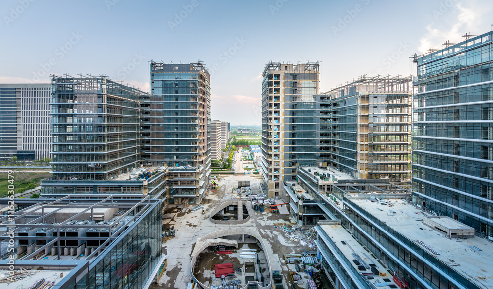 Fototapeta premium Modern city commercial building construction site at sunrise