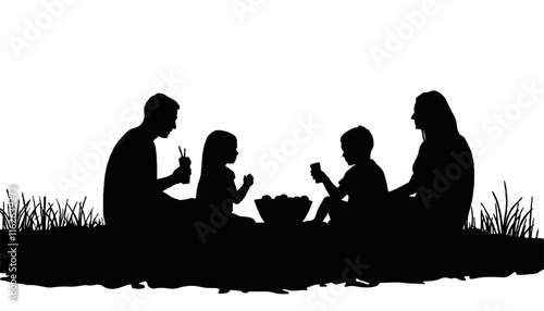 Silhouettes of family enjoying snacks in a grassy field