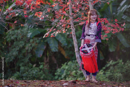 Women of Lisu Hill Tribe show colorful and beautiful traditional clothes walking in maple garden. photo