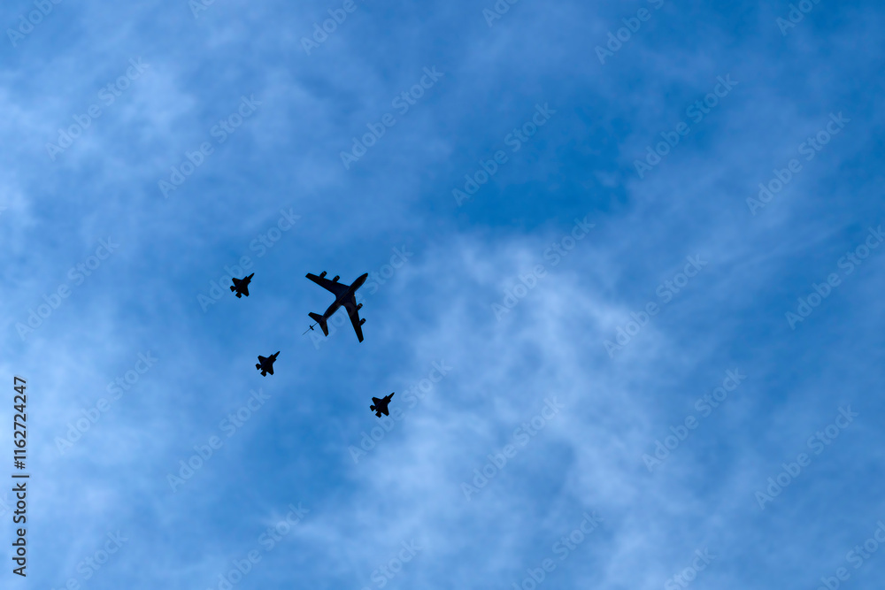 Four military airplanes silhouettes on a blue sky