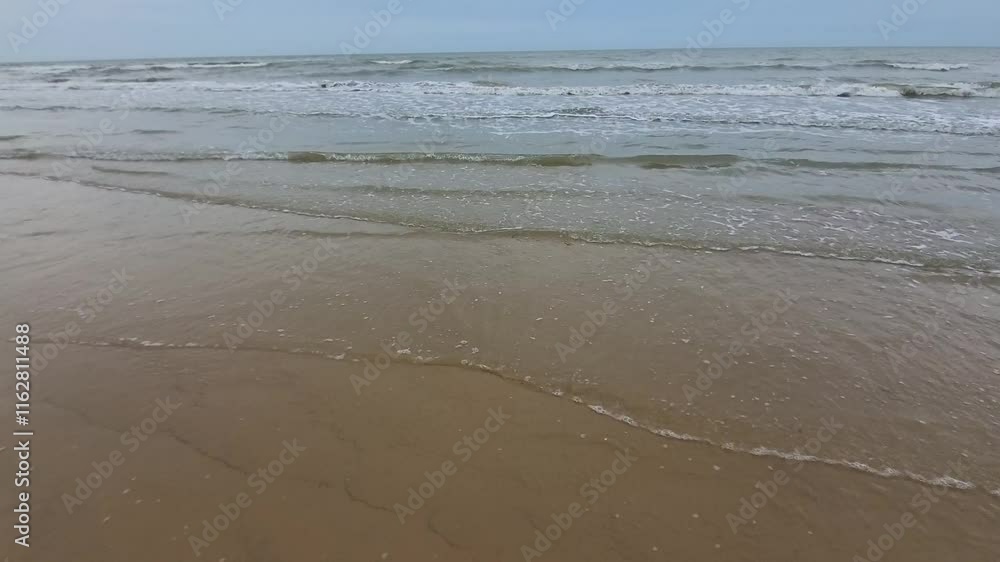 Beautiful view of waves on the beach in the afternoon when the weather is cloudy Beautiful view of waves on the beach in the afternoon when the weather is cloudy
