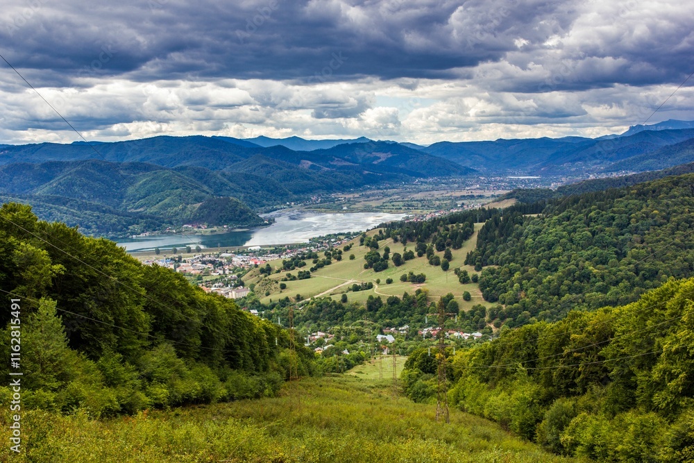 Mountains surrounding a lake and green forest in the middle of a valley Mountains surrounding a lake and green forest in the middle of a valley
