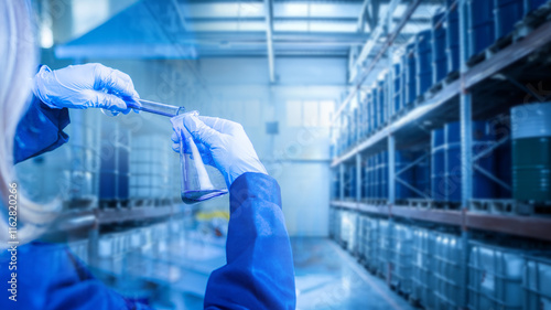 Woman laboratory technician at oil refinery. Checking fuel for quality. Inspector hands with flasks near warehouse. Control petroleum products for presence of impurities. Petroleum environmental test