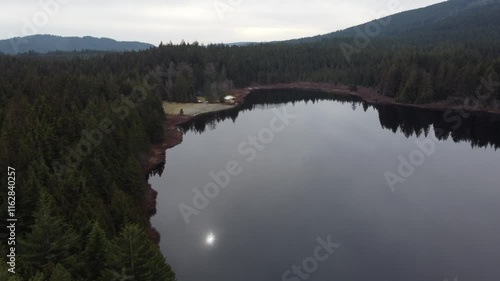 Wallpaper Mural Bird’s-eye view of calm lake with sun reflect and mountains under overcast skies Torontodigital.ca