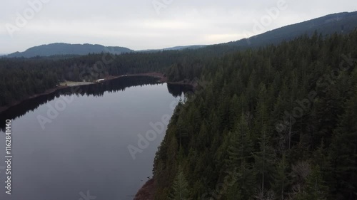 Wallpaper Mural A gentle glide over a still lake with mountains hidden in the clouds Torontodigital.ca