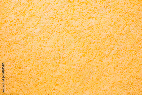 Close-up of a soft, textured yellow sponge cake surface, photo