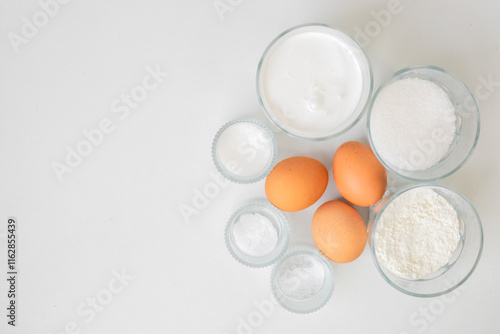 Baking ingredients like eggs, flour, and sugar are arranged on a white background, perfect for Easter baking ideas photo