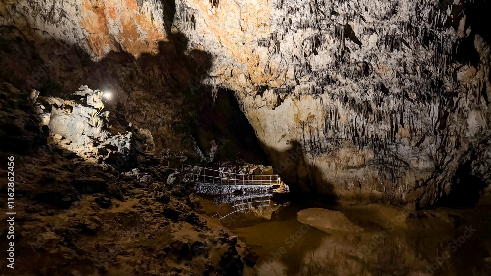 An adventurous explorer with a headlamp navigates a dark limestone cave, showcasing isolation and discovery An adventurous explorer with a headlamp navigates a dark limestone cave, showcasing isolation and discovery