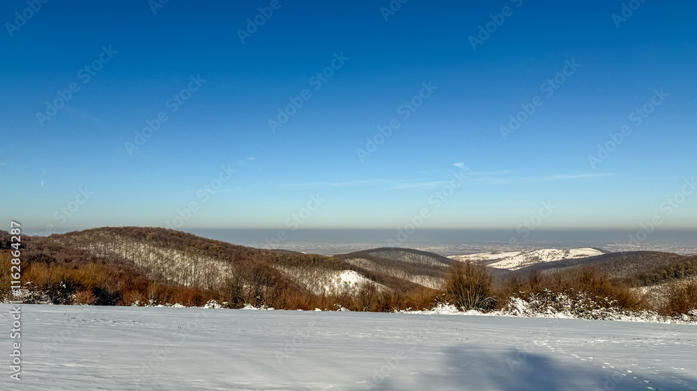 Snow-covered mountains under a clear blue sky capture the serene beauty of winter, evoking the tranquility of the holiday season Snow-covered mountains under a clear blue sky capture the serene beauty of winter, evoking the tranquility of the holiday season