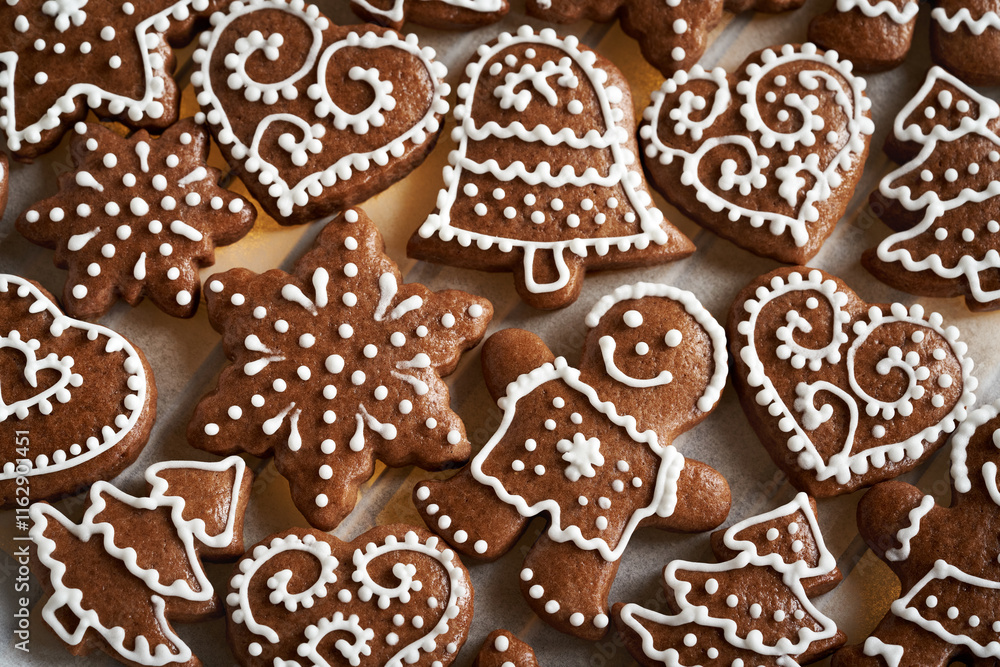 Homemade gingerbread Christmas cookie decorated with white icing on a sheet of baking paper, top view Homemade gingerbread Christmas cookie decorated with white icing on a sheet of baking paper, top view