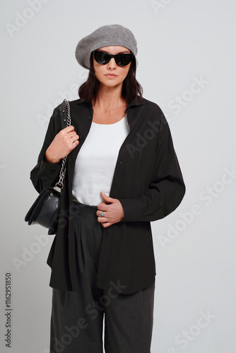 Portrait of an elegant brunette woman. Lady wears black shirt andf ashionable accessories. photo